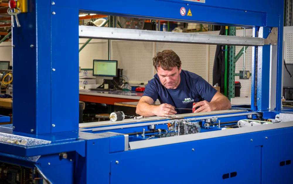 EAM-Mosca employee working on automatic strapping machine